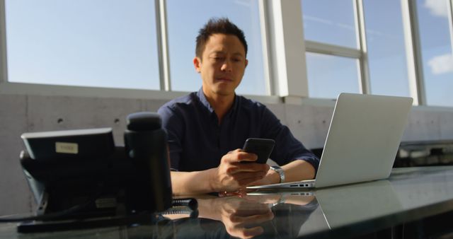 Businessman in Modern Office Working on Laptop and Smartphone - Download Free Stock Images Pikwizard.com