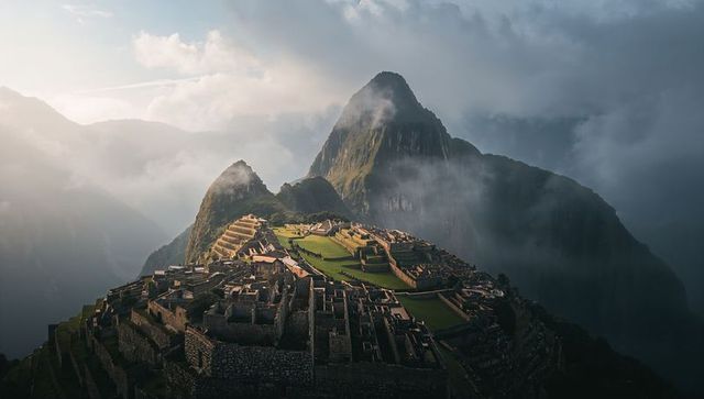Machu picchu dawn ruins bathing in mist and sunlight over andes terraces and peaks
