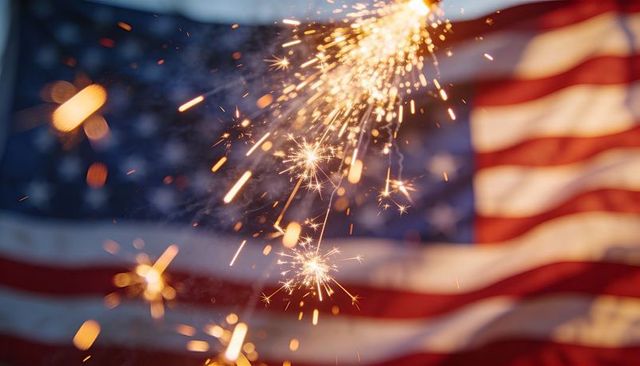 Waving american flag with sparkler sparks and golden bokeh at dusk