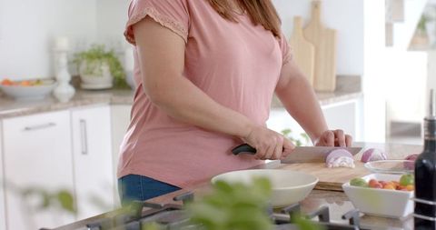 Woman Cutting Vegetables in Modern Kitchen