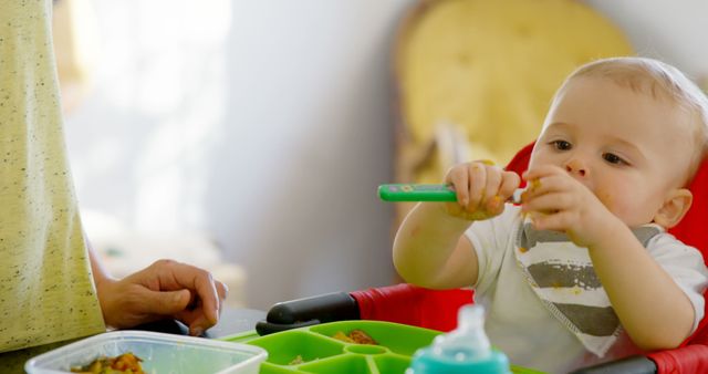 Toddler Eating with Spoon in High Chair During Mealtime - Download Free Stock Images Pikwizard.com