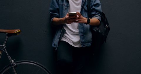 Casual young adult connecting via smartphone outdoors