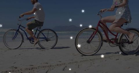 Couple Riding Bikes on Sandy Beaches Under Blue Skies