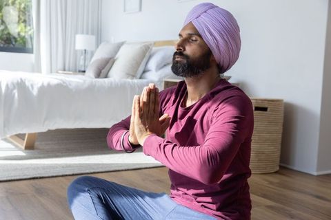 Indian Man Meditating in Modern Bedroom for Mindfulness and Relaxation