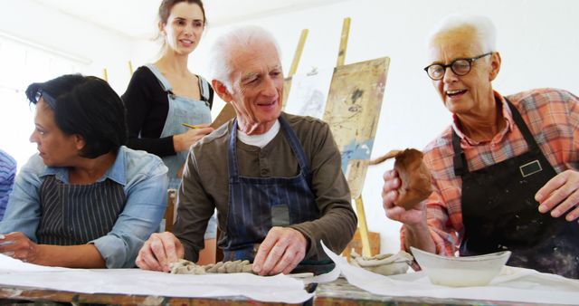 A diverse group of adults is engaged in a pottery class, with copy space. Senior individuals are shown enjoying the creative process alongside their younger counterparts, highlighting a community learning environment.