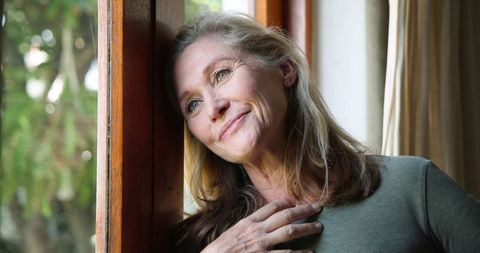 Senior Woman Contemplating Life by Window with Calm Demeanor