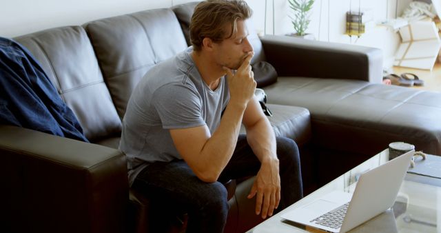 Man Deep in Thought While Working on Laptop in Living Room - Download Free Stock Images Pikwizard.com