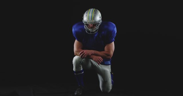 Football Player Kneeling on Dark Background in Full Gear - Download Free Stock Images Pikwizard.com