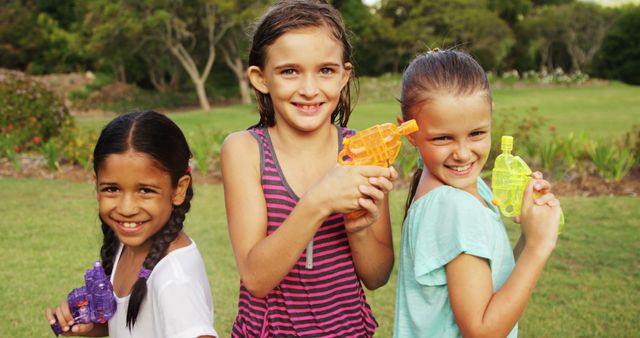 Cheerful Girls Playing with Water Guns Outdoors in Summer - Download Free Stock Images Pikwizard.com