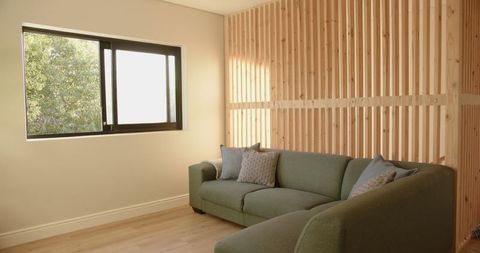 Modern living room with green l-shaped sofa and slatted wall design