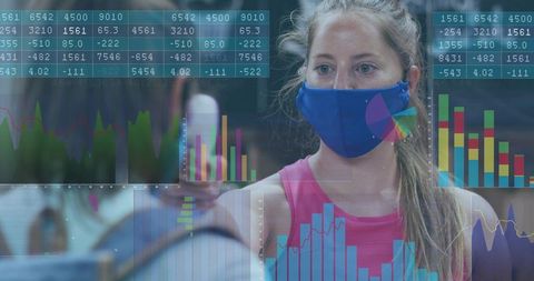 Young woman wearing blue cloth face mask training with fitness data overlays in gym mirror