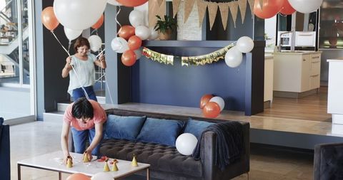 Senior women preparing living room for birthday celebration