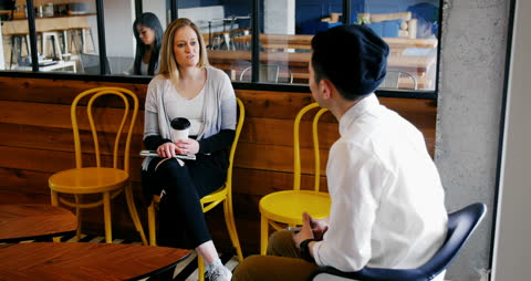 Diverse Colleagues Engaging in a Casual Cafe Conversation