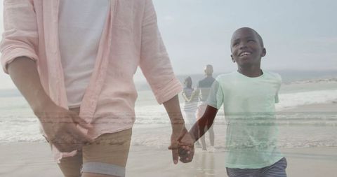 Father and Son Walking along Beach Hand in Hand