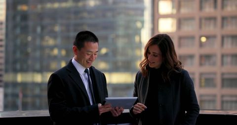 Business Professionals Collaborating with Tablet on Urban Balcony