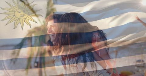 Happy couple enjoying beach vacation under uruguayan flag