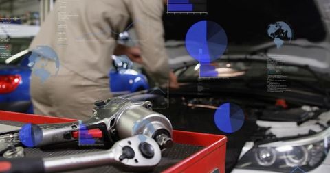 Mechanic Using Augmented Reality Diagnostics Working on Car Engine with Impact Wrench