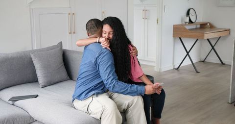Happy Couple Embracing After Pregnancy News at Home