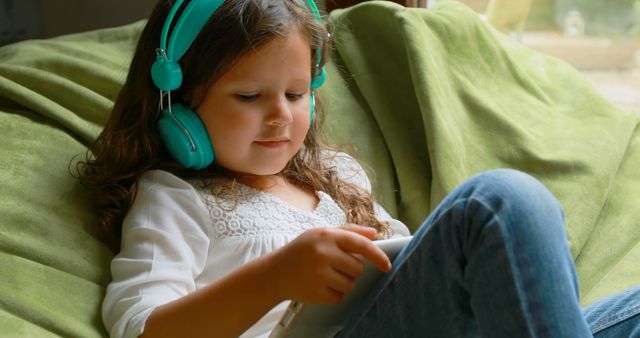 Young Girl Relaxing with Headphones and Digital Tablet on Sofa - Download Free Stock Images Pikwizard.com