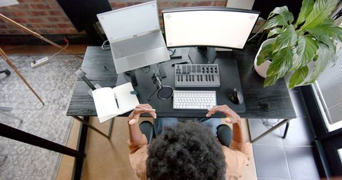 Home podcaster at work with audio equipment and monitors