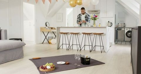 Man Preparing for Romantic Celebration at Home with Decor