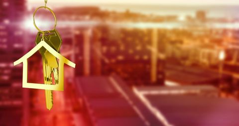 Golden House Key with Cityscape Background Symbolizing Real Estate Success