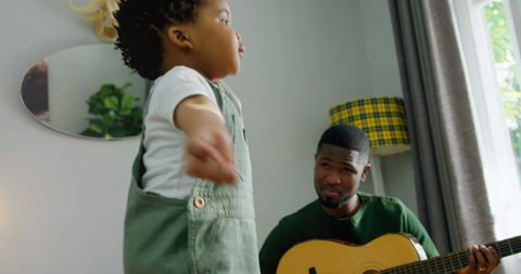 Father and Son Bonding Through Guitar Play at Home