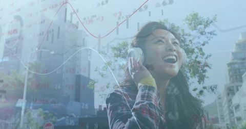 Young woman listening with headphones on urban street with financial data overlay