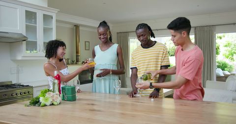 Celebratory gathering in kitchen: friends enjoying drinks together