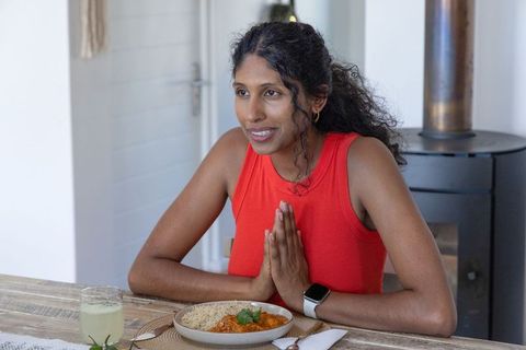 Practicing gratitude before meal at home dining table with rice curry and smartwatch