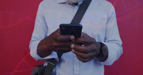 Commuter tapping smartphone wearing watch and crossbody bag on crimson background