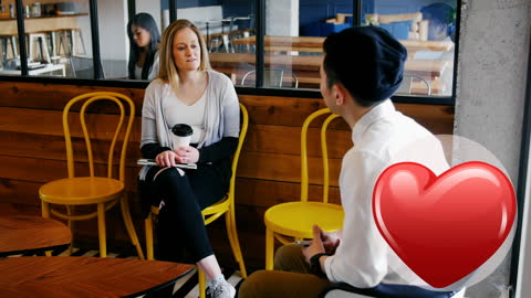 Two People Conversing in Cozy Cafe Setting with Digital Heart Icon