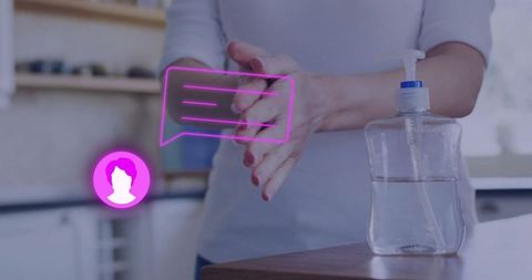 Woman using hand sanitizer in kitchen with digital overlay