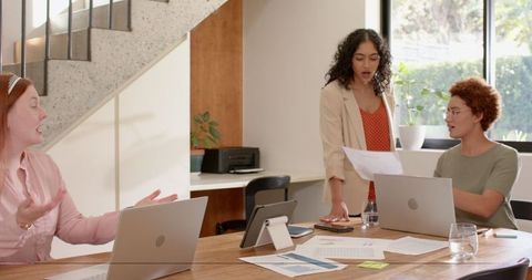 Diverse Female Coworkers Discussing Project in Modern Office