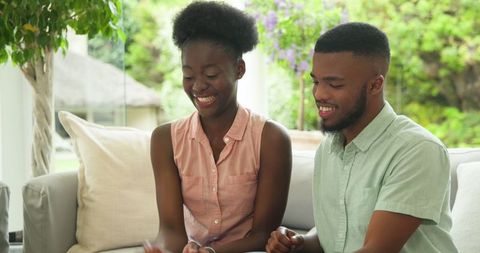 Smiling African American Couple Sharing Cupcakes on Cozy Patio