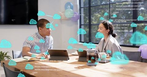 Collaborating over cloud apps at wooden table with tablets, augmented reality cloud icons and teamwo