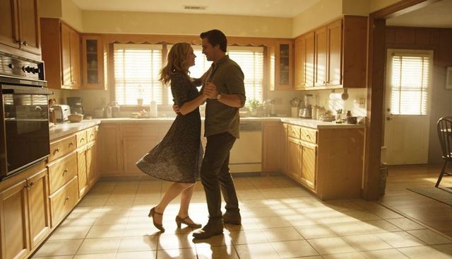 Sunlit kitchen couple slow dancing closely, holding each other, romantic cozy home moment
