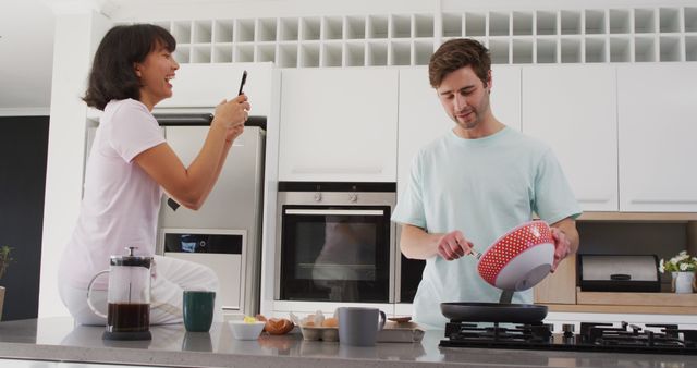 Image of happy diverse couple preparing breakfast together in kitchen. Love, relationship and spending quality time together concept.