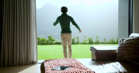 Man with Headphones Enjoying Mountain View from Cozy Living Room