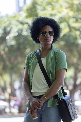 Urban african american man standing with coffee, wearing sunglasses and messenger bag