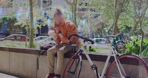 Man Enjoying Sandwich Near Bicycle in Urban Plaza