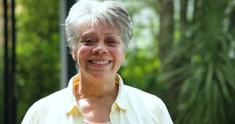 Cheerful Senior Woman Enjoying Vibrant Garden Scenery