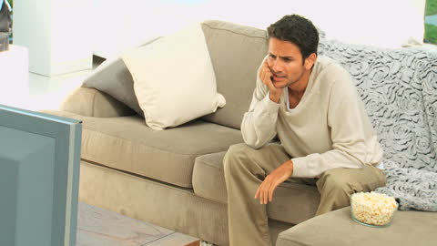 Young Man Watching Intense TV Show