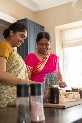Indian mother and daughter unpacking groceries in traditional sarees