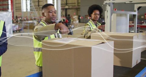Warehouse workers scanning and packing cartons on conveyor for efficient order fulfillment