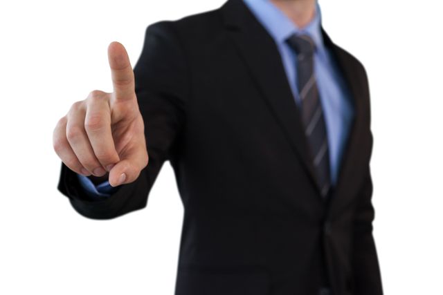 Mid section of businessman touching index finger on invisible screen while standing against white background