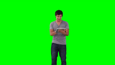 Man Using Tablet with Green Screen Background for Virtual Display
