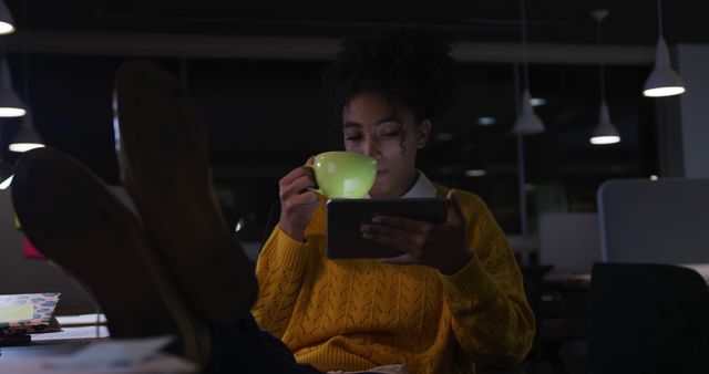 Woman Relaxing and Reading Tablet in Dimly Lit Room with Hot Beverage - Download Free Stock Images Pikwizard.com