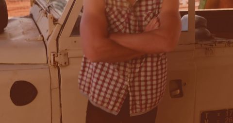 Caucasian Man with Crossed Arms Leaning on Car Outdoors