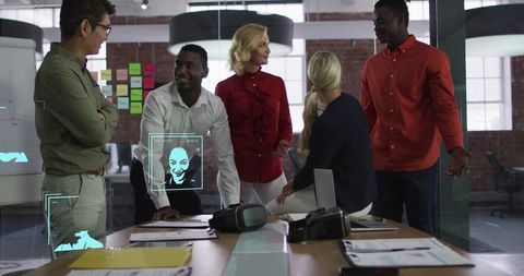 Creative team collaborating around table with vr headsets in modern coworking office